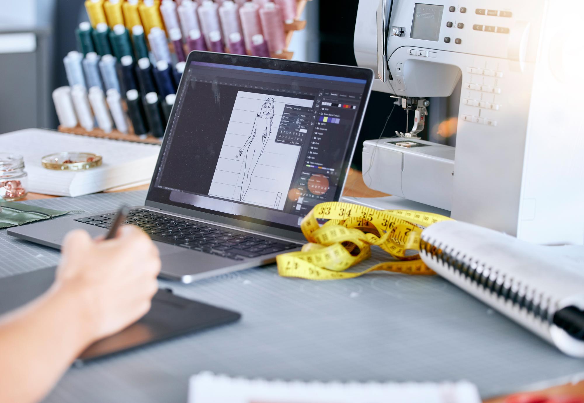 atelier workspace with threads and digitized patterns on a monitor